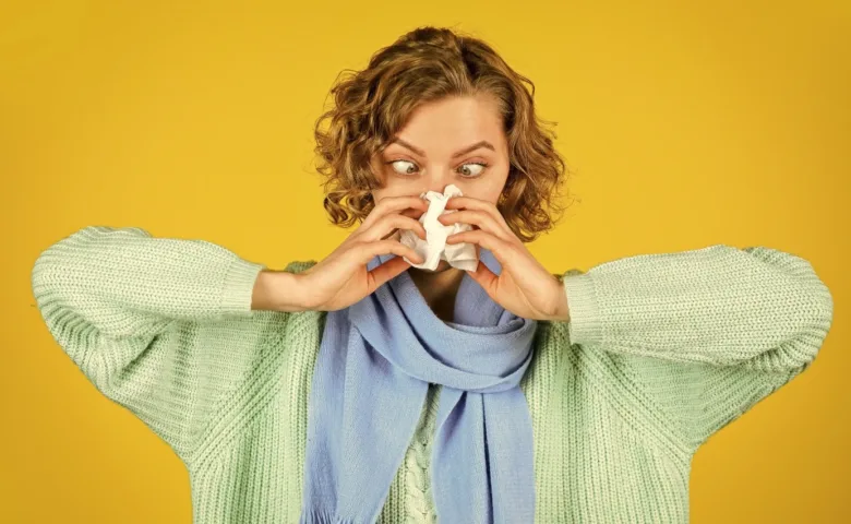 Woman sneezing into tissue