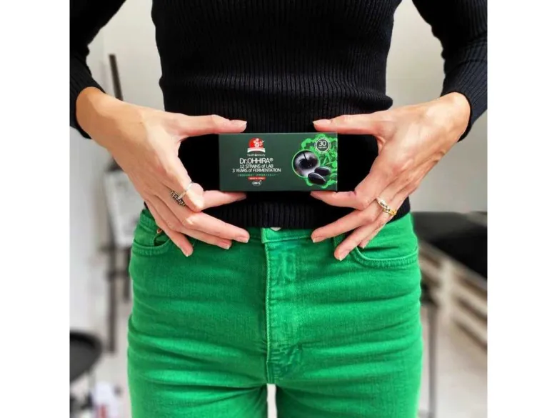 Žena drží v rukou krabičku s doplňkem stravy obsahujícím prebiotika.