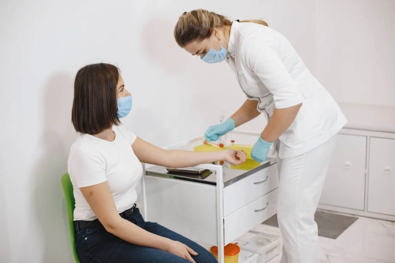 Sestra odebírá krev pacientovi pro laboratorní testy.