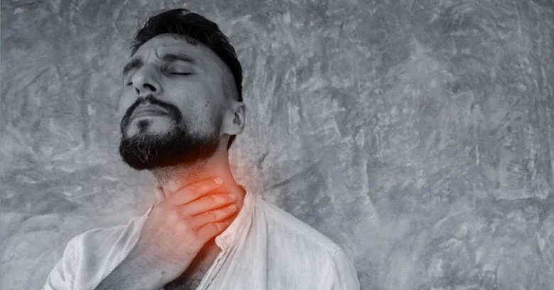 Man holding throat in pain