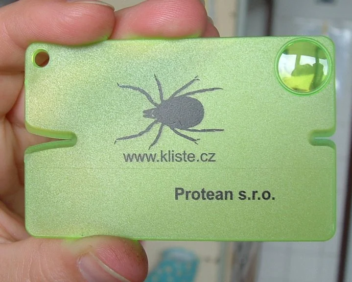 Zelený nástroj na vytažení klíště s obrázkem klíšete.