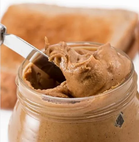 Peanut butter jar with knife and toast