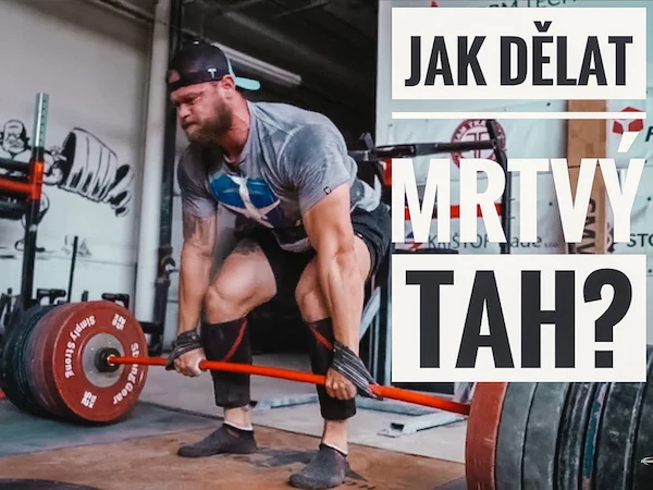 Muž dělá rumunský mrtvý tah s činkou v posilovně.