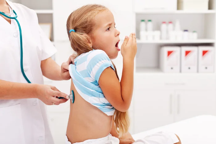 Doctor examining child coughing