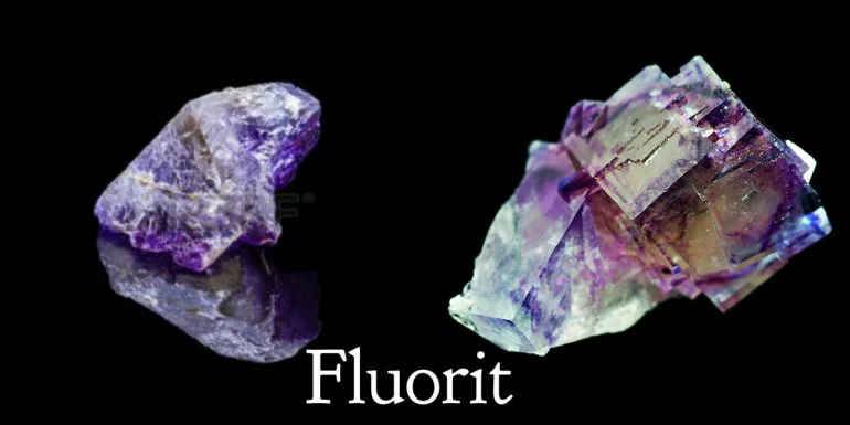 Dvě krystaly fluorit s fialovými odstíny na černém pozadí.