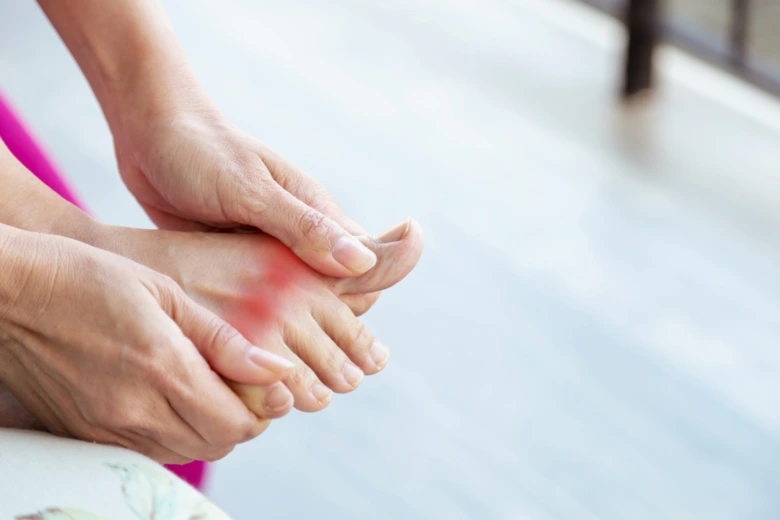 Person holding foot with gout pain
