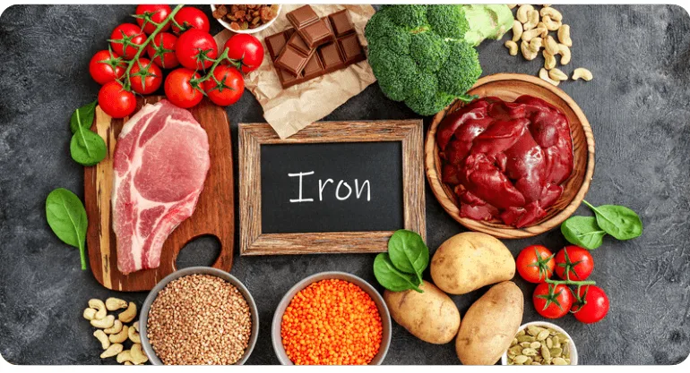 Různé potraviny bohaté na železo uspořádané kolem tabule s nápisem Iron.