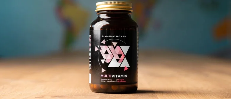 Fialová lahvička s vitamíny pro ženy na dřevěné ploše.