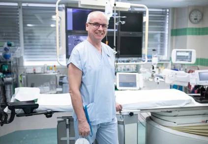 Lékař v nemocničním pokoji s lékařským vybavením.