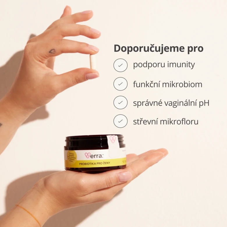 Ruce drží nádobu s probiotiky pro ženy a kapsulu.