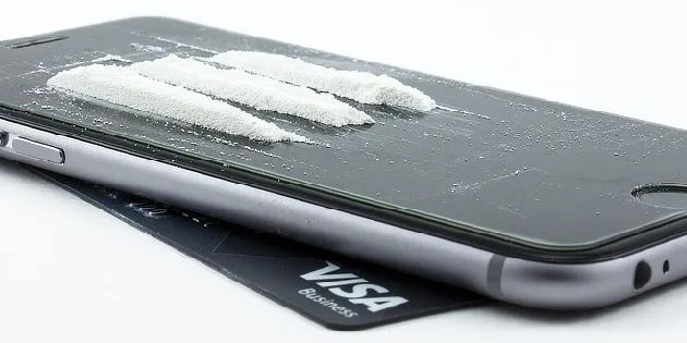 Bílá prášek na displeji mobilního telefonu.