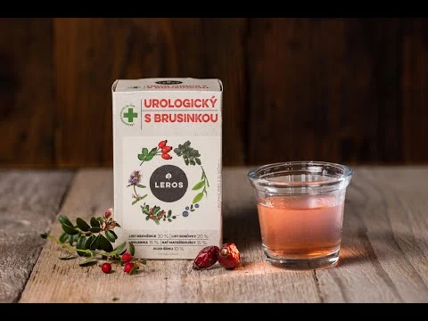 Krátká krabička urologického čaje s brusinkami vedle skleničky nápoje.