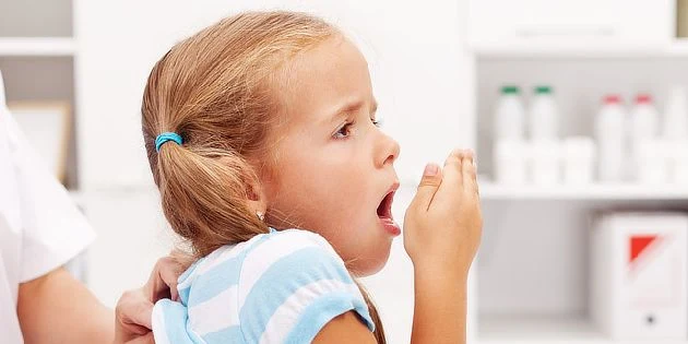 Dívka kašle v ordinaci při zhoršení příznaků nemoci.