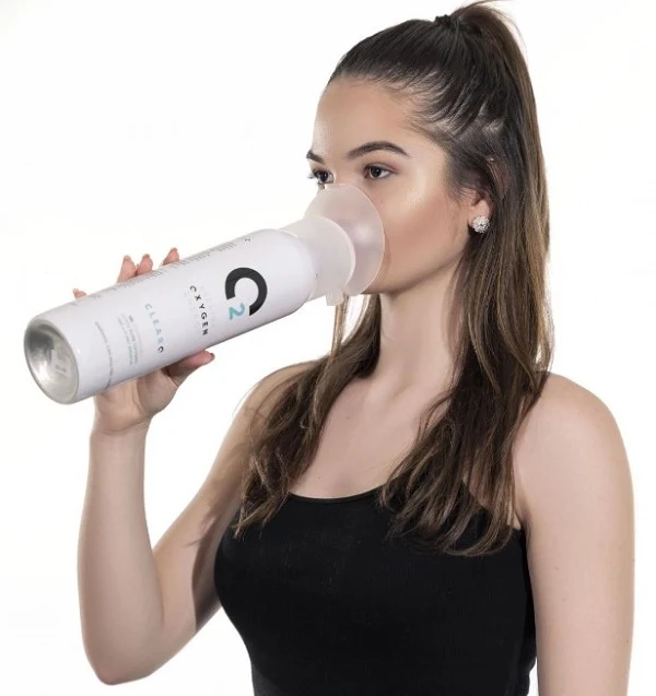 Žena dýchá do přenosného zařízení pro kyslíkovou terapii.