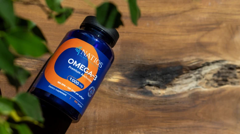 Modrá lahvička s doplňkem omega 3 na dřevě.
