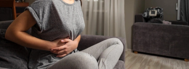 Žena drží břicho v bolesti bez menstruace