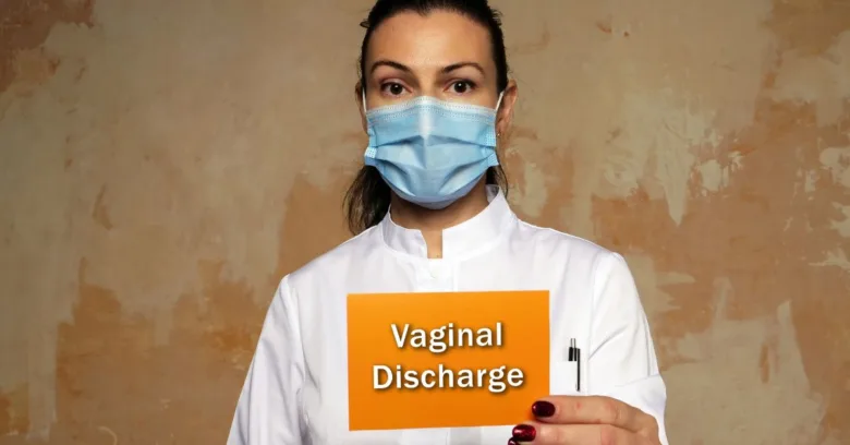 Žena v lékařském plášti drží tabuli s nápisem vaginální výtok.