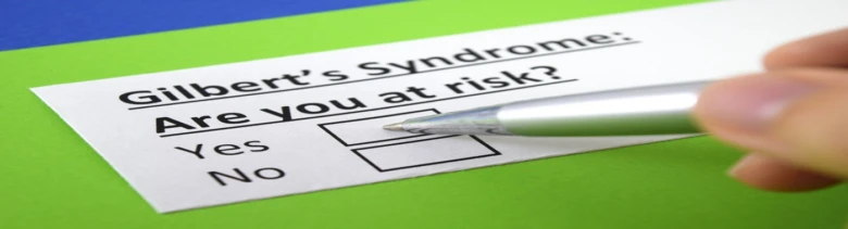 Ruka s tužkou vyplňuje formulář o riziku Gilbertova syndromu.