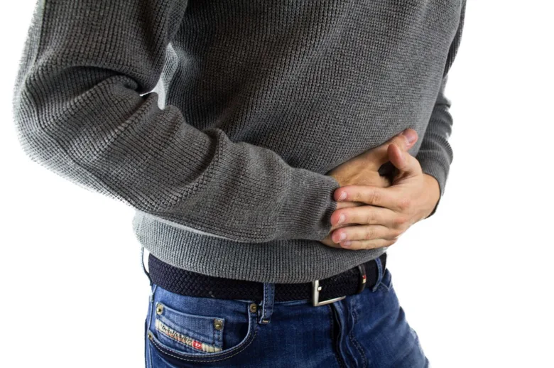Muž drží břicho v bolesti jako příznak syndromu dráždivého tračníku.