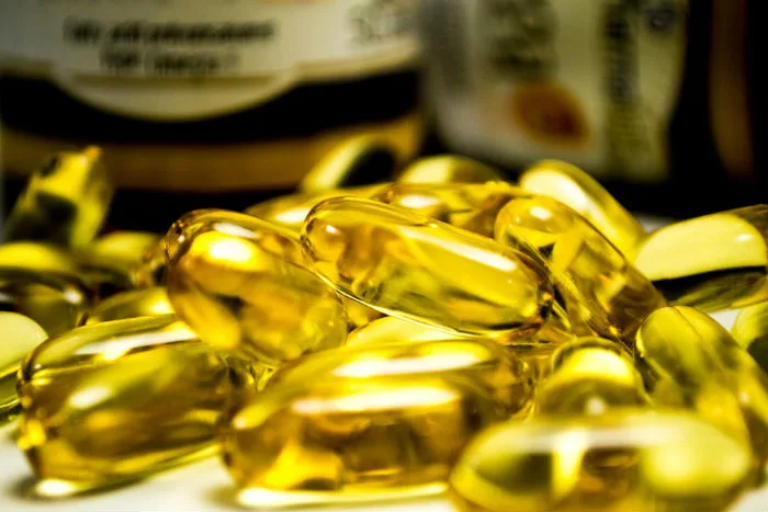 Skupina průsvitných žlutých kapslí s omega-3 mastnými kyselinami.