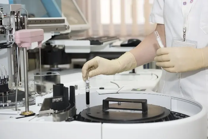 Laborantka s krví zkoumá vzorek ve laboratoři.