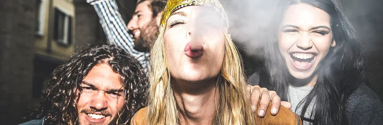 Skupina lidí kouřících drogy na ulici v noci.