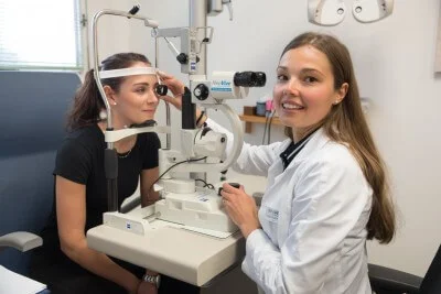 Oftalmologka zkoumá dítě na diagnostickém přístroji.