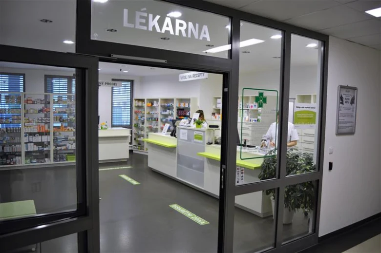 Vnitřní pohled do lékárny s regály plnými léků.
