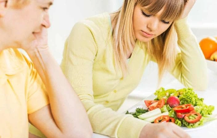 Žena se vyhýbá zeleninové salátě kvůli psychickému stresu.