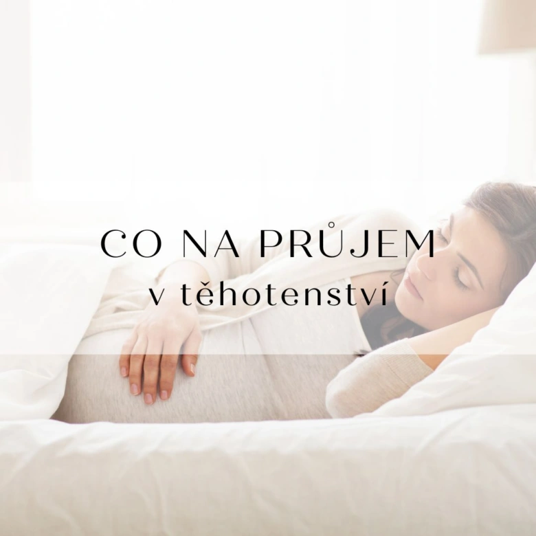 Těhotná žena spí v posteli s rukou na břiše.