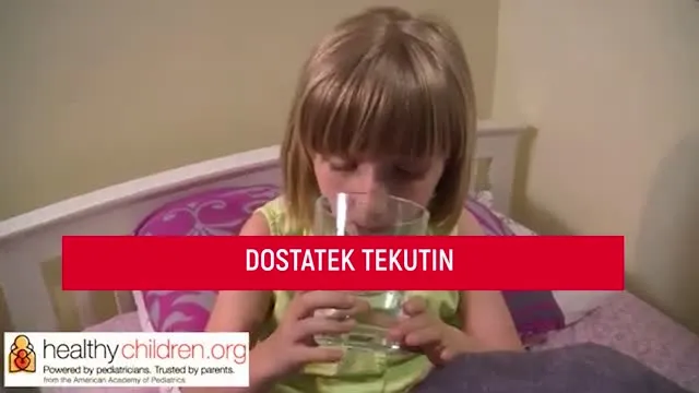 Děvčete pije vodu z sklenice na posteli.
