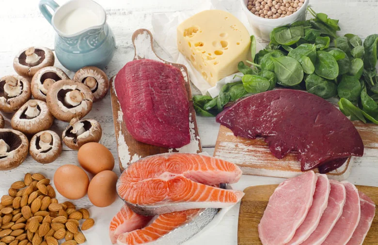 Různé potraviny bohaté na vitamín B jako maso, vejce a zelenina.