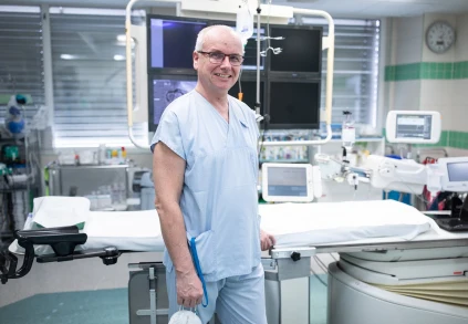 Muž lékař v nemocničním pokoji s vybavením pro péči o pacienty.