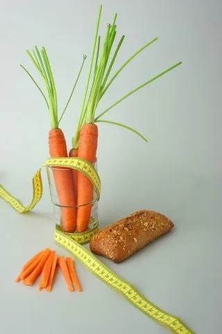 Mrkev v sklenici s páskou vedle celozrnného chleba.