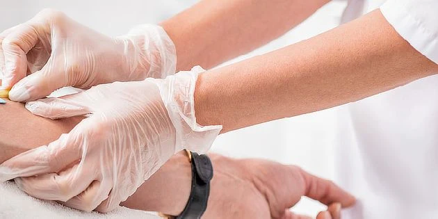 Zdravotník podává injekci pacientovi v rámci lékařského zákroku.