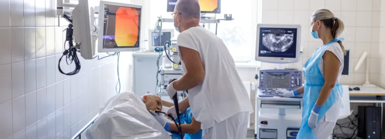 Lékaři provádějí vyšetření pacienta v nemocničním prostředí.