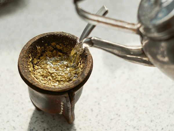 Voda se nalévá do dýgli s listy yerbamate.