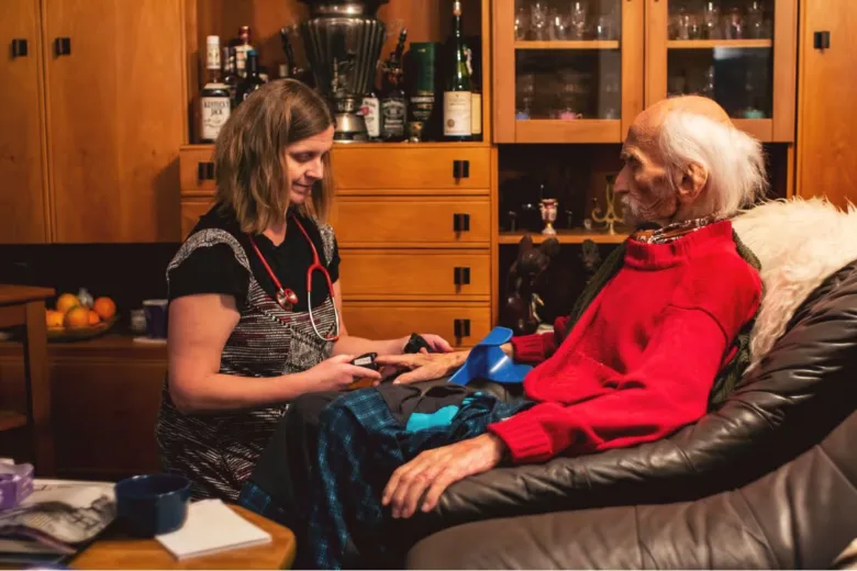 Příměstská hospicová sestra péče o starého muže v bytě.