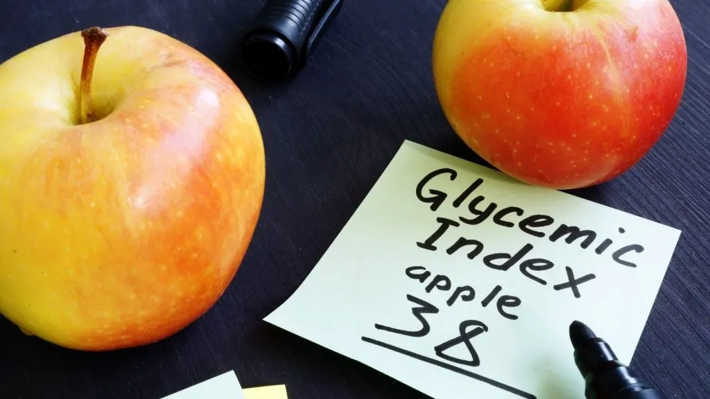 Dva jablka vedle poznámky s glykemickým indexem pro jablek.