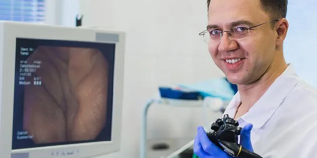 Lékař s endoskopem u monitoru ukazujícího polypy ve střevě.