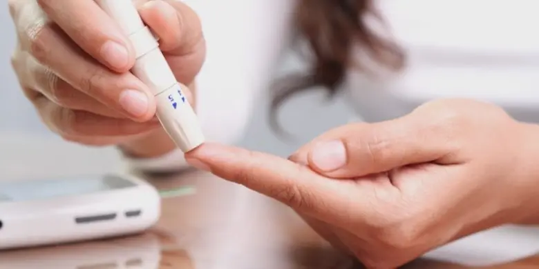 Krevní test na glukózu pomocí prstového propíchnutí.