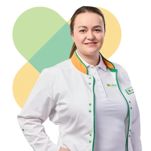 Usměvavá lékařka v bílém plášti s zelenými detaily.